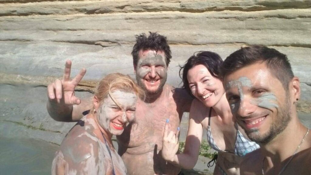 Autor bloga, njegova supruga i prijatelji mažu se lekovitim blatom na plaži Sidari, ostrvo Krf – tradicionalna lokalna zabava i wellness iskustvo.