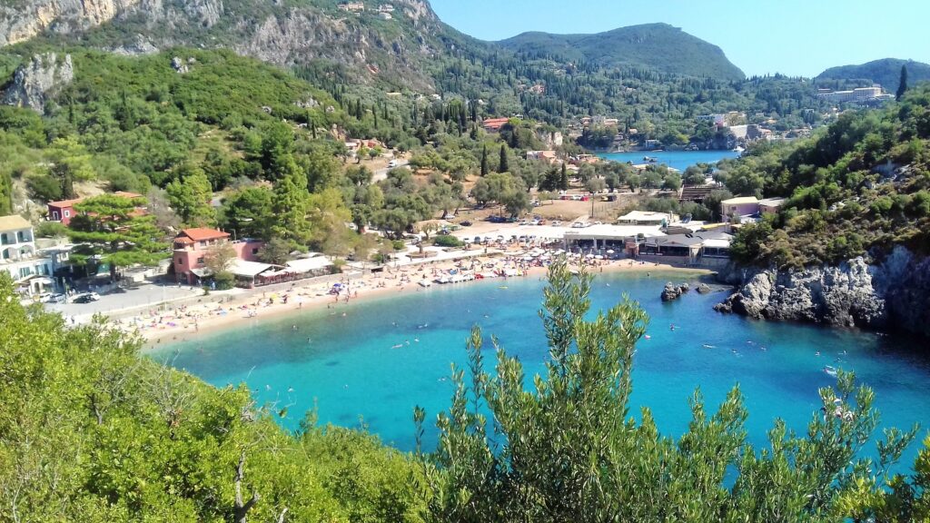 Paleokastrica – tirkizne uvale, strme stene koje se spuštaju u more, akvarijum sa morskim životom i manastir na brdu u pozadini.