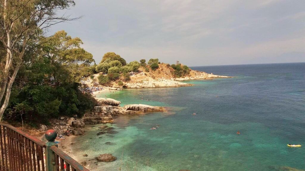 Kasiopi – stjenovita obala i duboko plavo Jonsko more, jutarnja tišina i pogled na udaljene planinske obrise.