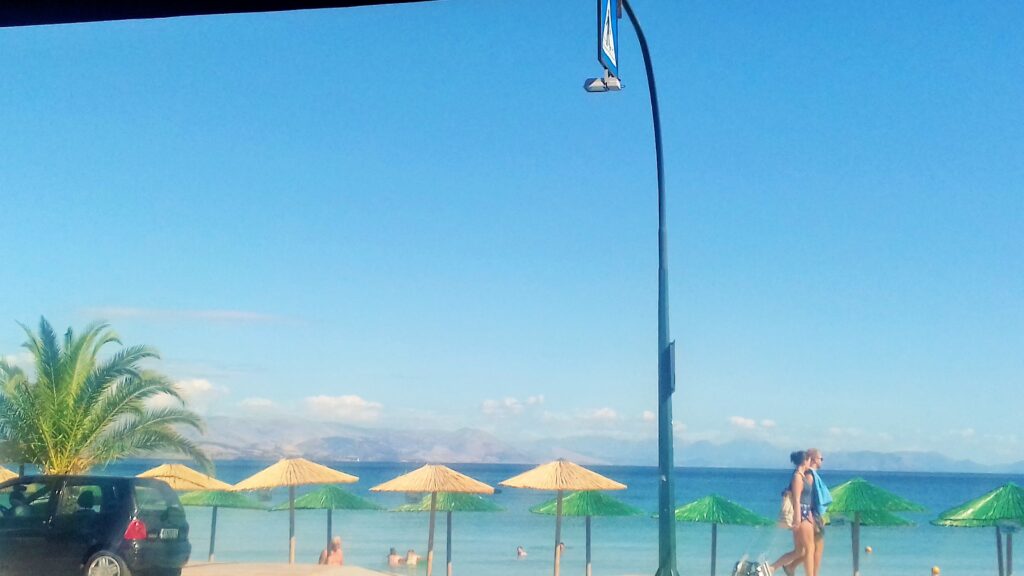 Ipsos – malo mesto na severu Krfa, plaže sa mekanim peskom, plitko plavo more i opuštena atmosfera mediteranskog ostrva.